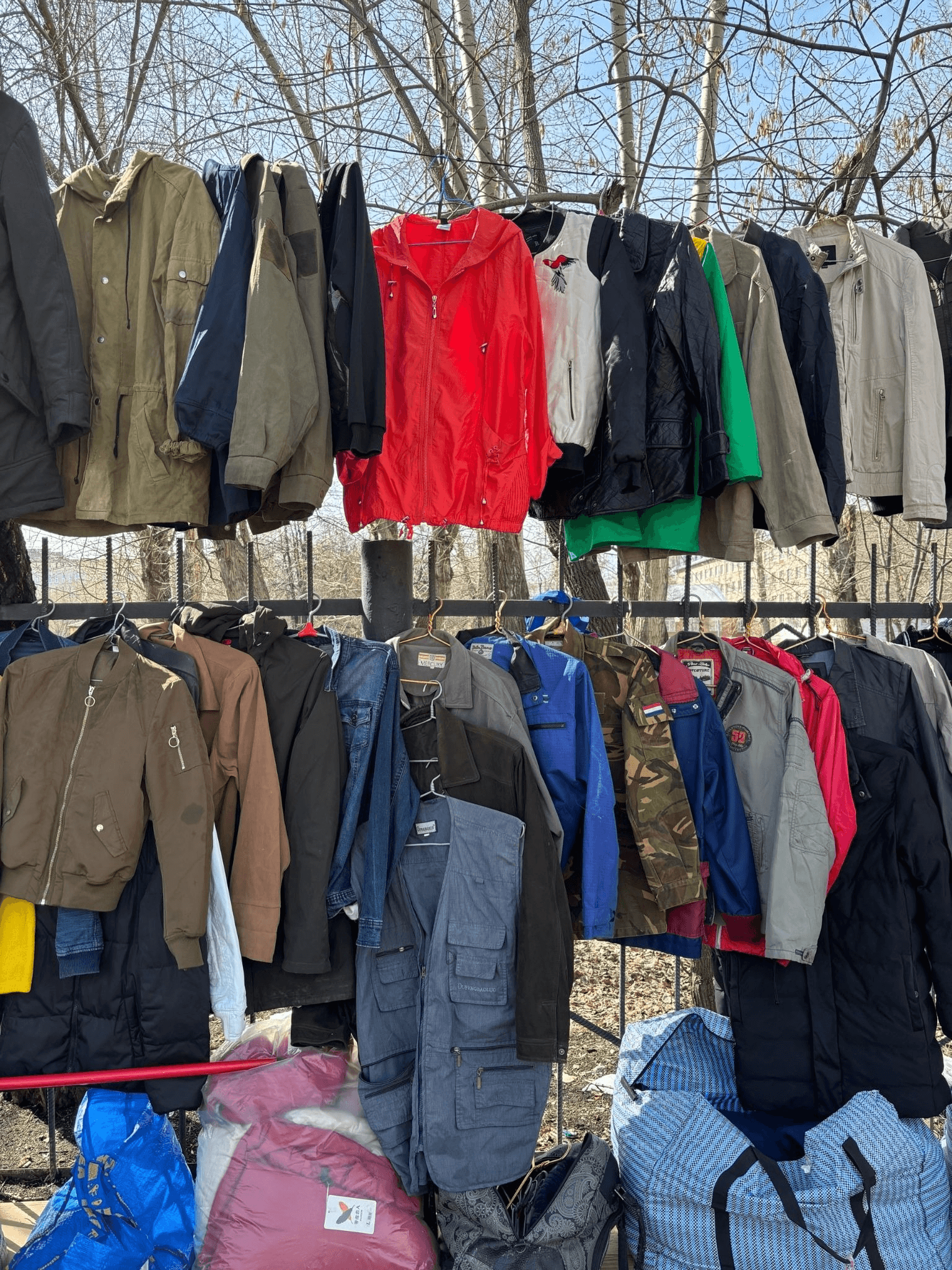 Забор с куртками на городской барахолке. Автор фото Анастасия Пелевина
